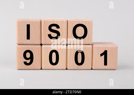 Internationale Organisation für Normung. Holzwürfel mit der Abkürzung ISO und der Nummer 9001 auf hellgrauem Hintergrund Stockfoto