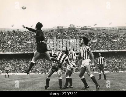 Das Spiel Madrid-Betis Atlético wurde am 20. März 1977 im Stadion Vicente Calderón ausgetragen und gilt für die erste Liga der Saison 1976-77. Atlético de Madrid gewann mit 3:1, mit Toren von Robi, Ayala (aus Elfmeterschießen) und Rubén Cano für die Heimmannschaft und Mühren (aus Elfmeterschießen) für die Besucher. Am Ende dieser Saison wurde Atlético de Madrid zum Meister der Liga und Betis zum Meister der Copa del Rey gekrönt. In The Image stellt der Torhüter Campos den Ball in Anwesenheit der Verdiblancos-Verteidiger Sabaté und Cobo sowie der Atléticoes Alberto und Ayala. (Foto Sa Stockfoto