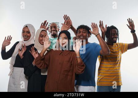 Eine jubelnde und vielfältige Gruppe, darunter ein Afroamerikaner und Hijab tragende Mädchen, winken und feiern überschwänglich und verkörpern die Lebendigkeit von Stockfoto