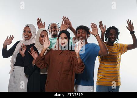 Eine jubelnde und vielfältige Gruppe, darunter ein Afroamerikaner und Hijab tragende Mädchen, winken und feiern überschwänglich und verkörpern die Lebendigkeit von Stockfoto