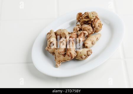 Kencur oder aromatischer Ingwer, bekannt als Cikur auf weißer Platte Stockfoto