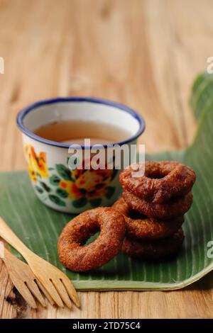 Ali Agrem Kue Ali, indonesischer Mini-Donut mit Tee. Ringkuchen aus Reismehl mit Kokospalmenzucker Stockfoto