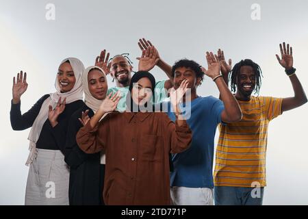 Eine jubelnde und vielfältige Gruppe, darunter ein Afroamerikaner und Hijab tragende Mädchen, winken und feiern überschwänglich und verkörpern die Lebendigkeit von Stockfoto