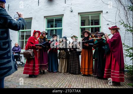 Deventer, Niederlande . Dezember 2023. Ein weiblicher Chor tritt in viktorianischen Kleidern auf. Jedes Jahr, um dieses Datum, lebt die Welt des englischen Schriftstellers Charles Dickens aus dem 19. Jahrhundert in der schönen niederländischen Stadt Deventer wieder. Mehr als 950 Charaktere aus den berühmten Büchern von Dickens zurück ins Leben. Wohlhabende Damen und Herren mit Spitzhüten ziehen durch die Straßen. Die Landschaft des Festivals besteht aus historischen Gebäuden, Weihnachtsbäumen und Tausenden von kleinen Lichtern. Quelle: SOPA Images Limited/Alamy Live News Stockfoto