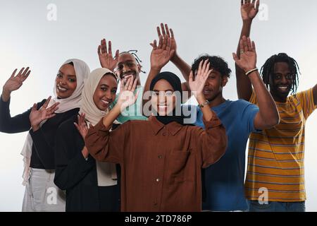 Eine jubelnde und vielfältige Gruppe, darunter ein Afroamerikaner und Hijab tragende Mädchen, winken und feiern überschwänglich und verkörpern die Lebendigkeit von Stockfoto