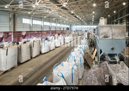 Riesige Plastiktüten mit Produkten auf Paletten in der Recyclingfabrik Stockfoto