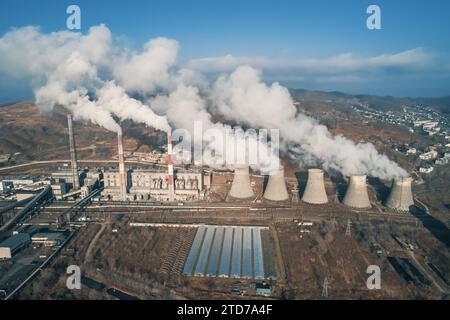 Luftaufnahme hoher Schornsteinrohre mit grauem Rauch aus Kohlekraftwerk. Stromerzeugung mit fossilen Brennstoffen. Ökologie und Verschmutzung der Natur. Stockfoto