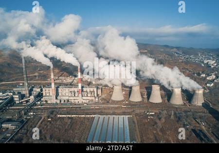 Luftaufnahme hoher Schornsteinrohre mit grauem Rauch aus Kohlekraftwerk. Stromerzeugung mit fossilen Brennstoffen. Ökologie und Verschmutzung der Natur. Stockfoto