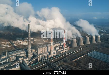 Luftaufnahme hoher Schornsteinrohre mit grauem Rauch aus Kohlekraftwerk. Stromerzeugung mit fossilen Brennstoffen. Ökologie und Verschmutzung der Natur. Stockfoto