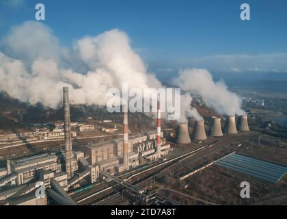 Luftaufnahme hoher Schornsteinrohre mit grauem Rauch aus Kohlekraftwerk. Stromerzeugung mit fossilen Brennstoffen. Ökologie und Verschmutzung der Natur. Stockfoto