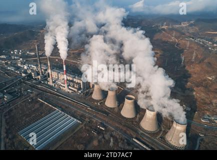 Luftaufnahme hoher Schornsteinrohre mit grauem Rauch aus Kohlekraftwerk. Stromerzeugung mit fossilen Brennstoffen. Ökologie und Verschmutzung der Natur. Stockfoto