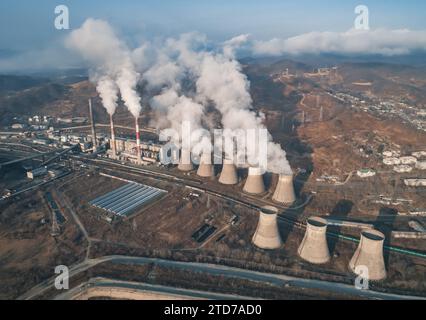 Luftaufnahme hoher Schornsteinrohre mit grauem Rauch aus Kohlekraftwerk. Stromerzeugung mit fossilen Brennstoffen. Ökologie und Verschmutzung der Natur. Stockfoto