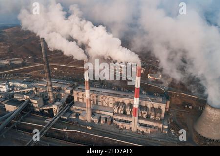 Luftaufnahme hoher Schornsteinrohre mit grauem Rauch aus Kohlekraftwerk. Stromerzeugung mit fossilen Brennstoffen. Ökologie und Verschmutzung der Natur. Stockfoto