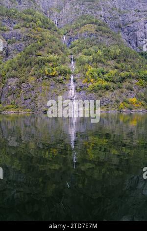 Ein kleiner Wasserfall vom Berg mit der Reflexion im Wasser. Stockfoto