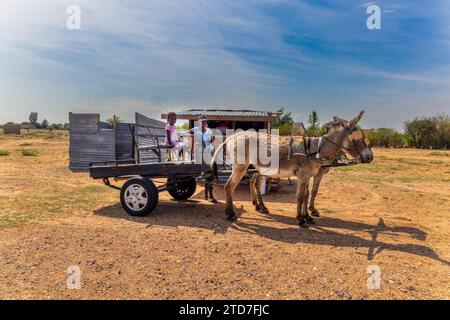 Eselkarre, Frau und Kind vor einem Straßenverkäufer in einer Hütte, die Snacks kauft, informelle Siedlung Stockfoto