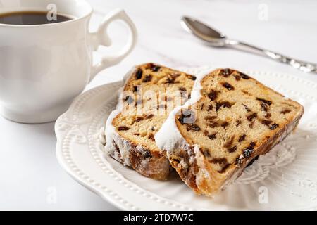Cristmass-Stollenscheiben auf einem Teller. Cristmass Holiday Breakfact Konzept. Nahaufnahme von zwei Scheiben traditionelles deutsches Weihnachtsbrot aus Nüssen und Gewürzen Stockfoto