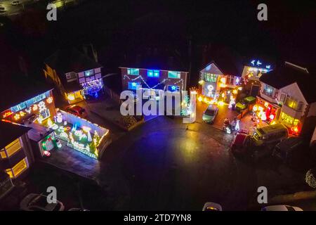 Poole, Dorset, Großbritannien. Dezember 2023. Eine der festlichsten Straßen Großbritanniens an der Runton Road in Poole, Dorset, wo die meisten Häuser mit bunten Weihnachtslichtern dekoriert sind, um Geld für wohltätige Zwecke zu sammeln. Die beleuchteten Weihnachtsausstellungen werden seit etwa zwanzig Jahren von den Bewohnern organisiert und sammeln Spenden der vielen Besucher für lokale Wohltätigkeitsorganisationen. Bildnachweis: Graham Hunt/Alamy Live News Stockfoto