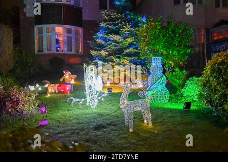 Poole, Dorset, Großbritannien. Dezember 2023. Eine der festlichsten Straßen Großbritanniens an der Runton Road in Poole, Dorset, wo die meisten Häuser mit bunten Weihnachtslichtern dekoriert sind, um Geld für wohltätige Zwecke zu sammeln. Die beleuchteten Weihnachtsausstellungen werden seit etwa zwanzig Jahren von den Bewohnern organisiert und sammeln Spenden der vielen Besucher für lokale Wohltätigkeitsorganisationen. Bildnachweis: Graham Hunt/Alamy Live News Stockfoto