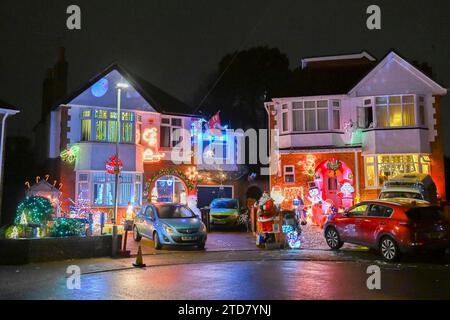 Poole, Dorset, Großbritannien. Dezember 2023. Eine der festlichsten Straßen Großbritanniens an der Runton Road in Poole, Dorset, wo die meisten Häuser mit bunten Weihnachtslichtern dekoriert sind, um Geld für wohltätige Zwecke zu sammeln. Die beleuchteten Weihnachtsausstellungen werden seit etwa zwanzig Jahren von den Bewohnern organisiert und sammeln Spenden der vielen Besucher für lokale Wohltätigkeitsorganisationen. Bildnachweis: Graham Hunt/Alamy Live News Stockfoto