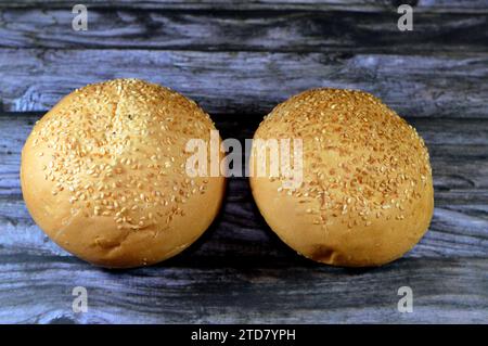 Runde, handgroße Hamburger-Brötchen, gebacken und mit Sesamsamen bedeckt, Brötchen ist eine Art Brötchen, in der Regel gefüllt mit herzhaften Füllungen, hergestellt aus fr Stockfoto