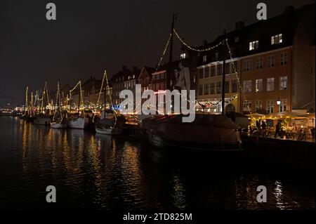 Eine Flotte von mit Weihnachtslichtern geschmückten, vertäuten Booten auf dem Nyhavn-Kanal in Nyhavn, einem Viertel von Kopenhagen für seine berühmte breite Auswahl an Outdoor-/ Stockfoto