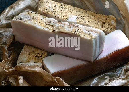 Vier große Stücke gesalzenes Schweineschmalz mit Knoblauch auf Pergamentpapier Stockfoto