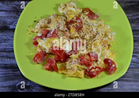 Eier mit Tomaten gerührt, ein Gericht aus Eiern, die unter schonendem Erhitzen mit Salz, Butter, Öl und schwarzem pe gerührt, geschlagen oder zusammengeschlagen werden Stockfoto