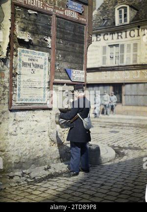 Reims, Marne, Champagne, Frankreich Postmann, Postversammlungen, Alltag, Kleidung, Inschrift, Informationen, erster Weltkrieg, Menschen, Post, Straßenszene, Arbeitskleidung, Poster, Rückansicht, Kriegsanstrengungen, Kriegsarbeit, Mann, Frankreich, Postman macht seine Runde, Reims, 01.01/1917 - 31.12.1917, Castelnau, Paul, 1917: Marne - Fernand Cuville (fotografischer Teil der Armee), Autochrome, Foto, Glas, Autochrome Foto, positiv, Vertikal, Format 9 x 12 cm Stockfoto