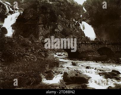 Rjukan, Norwegen kleine Steinbrücke am Fuße eines Wasserfalls, Natur, Umwelt, Habitat, Architektur, Landschaft, Wasserfall, Bauingenieurwesen, Wasserlauf, Hydrografie, Schlucht, Brücke, Norwegen, Straße von Sejelstad nach Odda, Rjukan, 10/09/1910 - 10/09/1910, Wilse, anders Beer, 1910 - Albert Kahn und Auguste Léon reisen nach Skandinavien (9. August-14. September), Gélatino-argentique, Glas, positiv auf Glas schwarz-weiß viré, positiv, horizontal, Größe 9 x 12 cm Stockfoto