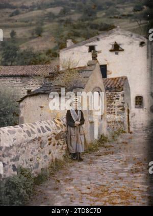 Saurier, Frankreich, Menschen, Kleidung, Zuhause, Architektur, Frau, Kostüm, Ländliche Architektur, Gepflasterte Straße, Haarfrisur, Kopfbedeckung, Bridge, Frankreich, Saurier, alte Frau von Saurier, Saurier, 09.09/1916 - 09.09.1916, Passet, Stéphane, Fotograf, 1916-1917 - Auvergne - Stéphane Passet - (September 1916 - Februar 1917), Autochrome, Foto, Glas, Autochrome, Foto, positiv Stockfoto