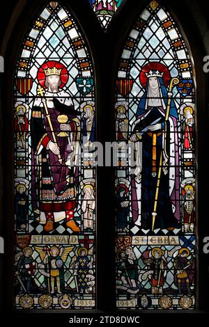 St. Oswald und St. Ebba wie in Buntglas dargestellt. Das Kriegsdenkmal-Fenster. St Ebba's Church, Beadnell, St Ebba Church, Beadnell, Northumberland, UK Stockfoto