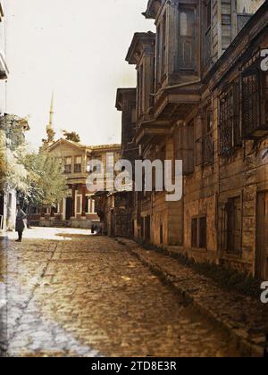 Konstantinopel (das heutige Istanbul), Türkei Eine Kopfsteinpflasterstraße in Eyüp, gesäumt von zweistöckigen Holzhäusern (im Hintergrund ein Minarett), Wohnhäusern, Architektur, Menschen, Wohnung, Straße, Bezirk, Mann, Türkei, Constantinople, One rue d’Eyoule, Istanbul, 01/09/1912 - 30/09/1912, Passet, Stéphane, Fotograf, 1912 - Turquie - Stéphane Passet - (September), Autochrome, Foto, Glas, Autochrome, Foto, positiv, Vertikal, Format 9 x 12 cm Stockfoto