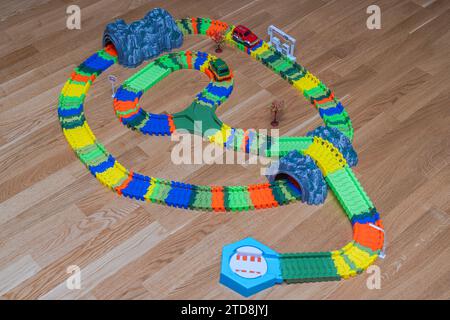 Blick auf die farbenfrohe Click-Road für die lebendige Miniatur-Spielzeugbahn auf Holzboden. Stockfoto