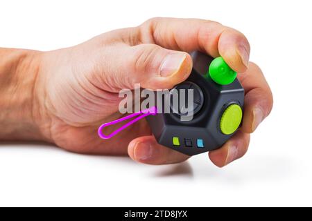 Nahaufnahme einer männlichen Hand, die ein beliebtes Stressentlastungsspielzeug hält, isoliert, auf weißem Hintergrund. Stockfoto