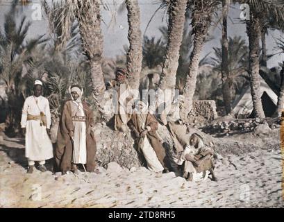 Aqaba, Arabien (heutiges Jordanien) Gruppe von Kämpfern aus der Armee des Königreichs Hejaz, Kleidung, HD, Menschen, Habitat, Architektur, Natur, Umwelt, Kostüm, Zelt, Palme, Palmenhain, Beduinen, existiert in High Definition, Porträt, Wohnung, Zubehör, Slave, Gürtel, Frisur, Kopfbedeckung, Vegetation, Botanik, man, Arabien, Akaba, Gruppe im Palmenhain, Akaba, 28.03/1918 - 28.03.1918, Castelnau, Paul, 1918 - Nahost, Ägypten, Palästina, Chypre - Paul Castelnau (fotografischer Teil der Armee) - (9. Januar-6. Oktober), Autochrome, Foto, Glas, Autochrome, Foto, positiv, Stockfoto
