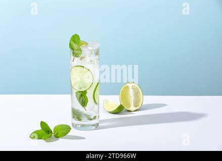 Eis und Mojito im Glas liegen mit starkem Schatten auf dem Tisch Stockfoto