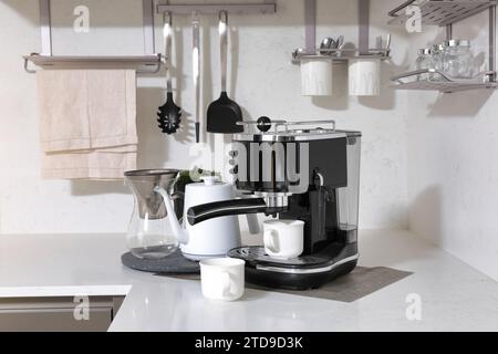 Waschbecken mit Küchenutensilien und Kaffeemaschine Stockfoto