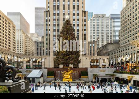 Rockefeller Center während der Weihnachtszeit mit Leuten, die tagsüber auf der Eisbahn vor dem Baum Schlittschuhlaufen. Stockfoto