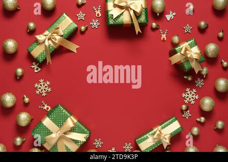 Rahmen aus Geschenkboxen mit Weihnachtsdekoration auf rotem Hintergrund Stockfoto