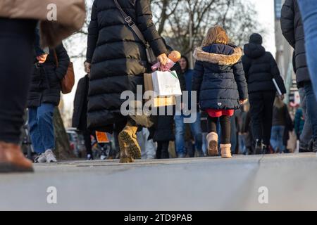 Weihnachtseinkäufe am Dritten Advent in Berlin, Deutschland - 17. Dezember 2023: Menschen tragen Einkaufstragetaschen und erledigen Weihnachtseinkäufe auf einer bekannten Einkaufsstraße, der Tauentzienstraße, am verkaufsoffenen Sonntag am dritten Advent in Berlin Stockfoto