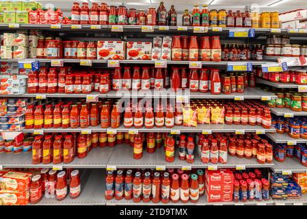 Italien - 15. Dezember 2023: Soße- und Tomatenpüree in Gläsern und Flaschen verschiedener Typen und Marken zum Verkauf in italienischen Super-Regalen Stockfoto