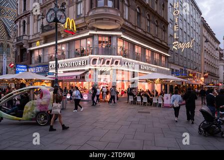 Wien, Österreich 30 september 2023 das berühmte Aida Cafe und Hotel Royal in einer geschäftigen zentralen Straße in der Abenddämmerung Stockfoto