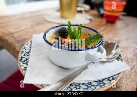 Traditionelles französisches Gourmet-Dessert Creme Brulee serviert mit Früchten und Beeren Stockfoto