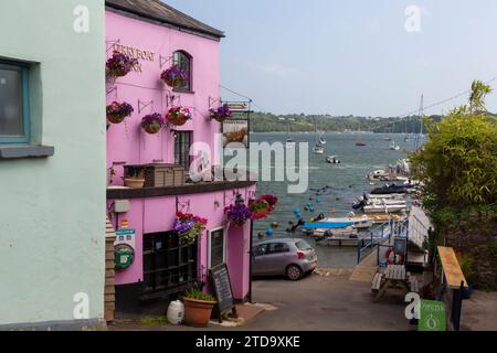 Dittisham Riverside Pub und Blick auf die Straße mit Blick auf die Main Street bis zur Waterfront mit vertäuten Booten auf dem Yachthafen und dem River Dart. Stockfoto