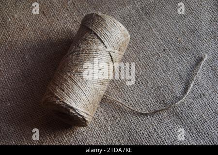 Fadenstücke auf Sackleinen. Gelbes Gewinde auf grobem Tuch. Stockfoto