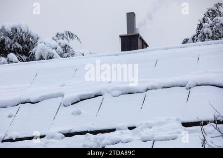 Schneebedeckte Sonnenkollektoren auf dem Dach: Winterfeste erneuerbare Energien Stockfoto