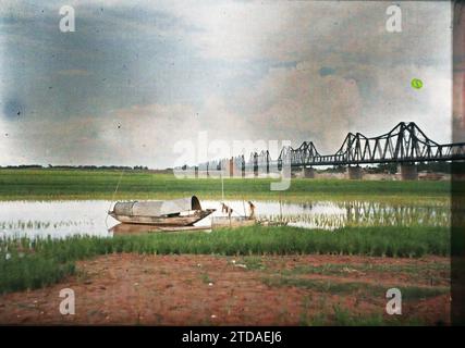 Hà-nôi, Hainoi Vietnam, Tonkin, Indochina Reisfelder und ein Sampan am Ufer des Roten Flusses, in der Nähe der Doumer Brücke, Wirtschaftstätigkeit, Wohnraum, Architektur, Verkehr, Reisfeld, Landwirtschaft, Viehzucht, Fluss, Tiefbau, Boot, Metallurgie, Flusstransport, See, Brücke, Indochina, Tonkin, Hanoi, die Kais des Red River, die Doumer Bridge, Fleuve rouge, Quartier Sino-annamite, 01.09/1915 - 30.11.1915, Busy, Léon, Léon Busy Photographer en Indochine, Autochrome, Foto, Glas, Autochrome, Foto, positiv, Horizontal, Format 9 x 12 cm Stockfoto