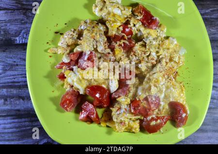 Eier mit Tomaten gerührt, ein Gericht aus Eiern, die unter schonendem Erhitzen mit Salz, Butter, Öl und schwarzem pe gerührt, geschlagen oder zusammengeschlagen werden Stockfoto