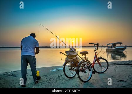 Coastal Serenity: Anglerfischen in Dammam Corniche, Saudi-Arabien mit Bicycle Companion. Stockfoto