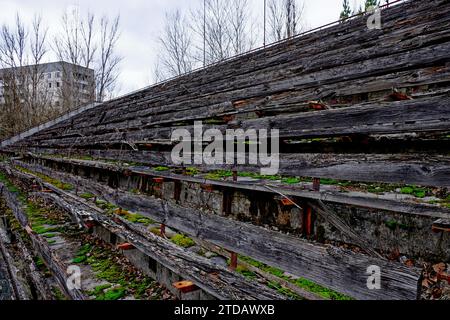 Alte Holztreppe in der Altstadt von Pripyat, Ukraine. Die Tribüne eines verlassenen Stadions in Pripyat. Alte Holzbänke im Stadion. Stockfoto